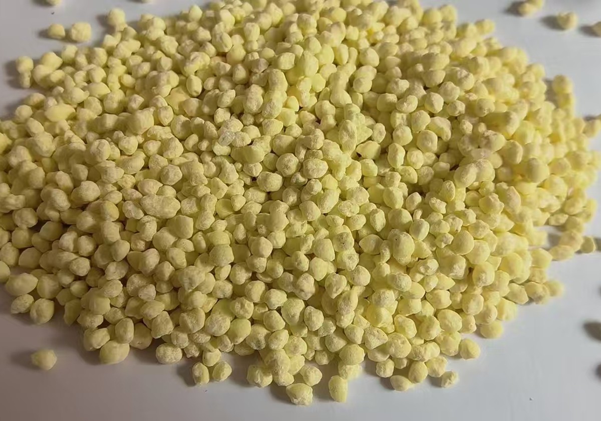 Yellow NPK fertilizer granules sample